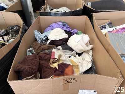 de nombreux cartons remplis de vêtements qui traînent par terre