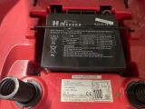 the battery of a red lawn mower with a black label on it