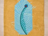 une photo d'un tapis sur lequel se trouve une plume bleue