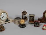 many different types of clocks displayed on a table