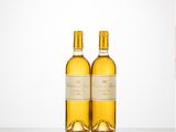 two bottles of wine sitting on top of a table next to each other