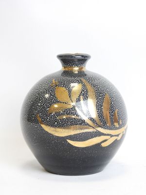 a black vase with a gold leaf design on it