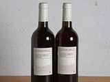 deux bouteilles de vin posées sur une table l'une à côté de l'autre