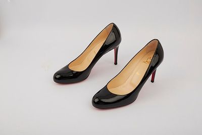 a pair of black high heels on a white surface