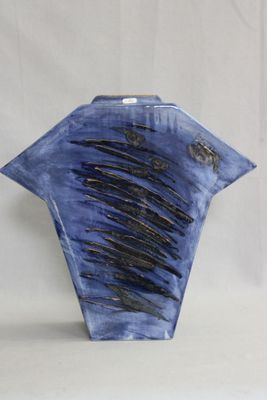 un vase bleu orné de lignes noires sur fond blanc