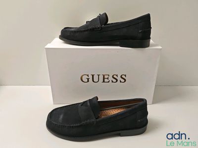 Des mocassins en cuir noir avec des pompons sur la semelle, je suppose