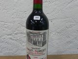 une bouteille de vin rouge posée sur une table en bois