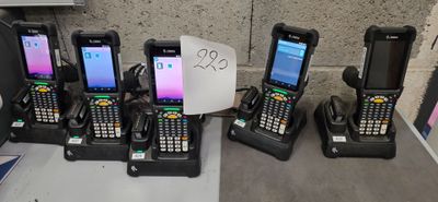Plusieurs téléphones portables sont alignés sur une table à côté d'un panneau