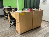 a desk with a file cabinet and chairs in an office
