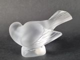 a glass bird that is sitting on top of a table