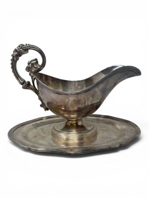 an antique silver plate with a saucer on it on a white background