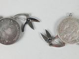 two coins and a pair of scissors on a white surface
