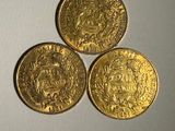 trois pièces d'or empilées les unes sur les autres sur une table