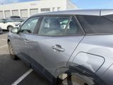 a silver car parked in a parking lot next to a building