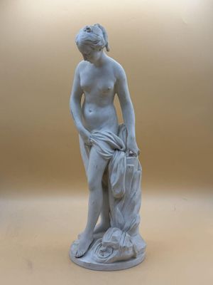une statue représentant un garçon avec un sac, posée sur une table