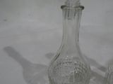 une carafe en verre et deux verres posés sur une table