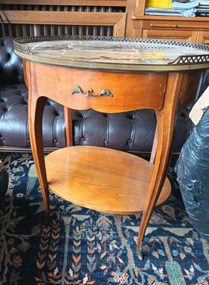 une petite table avec un plateau en marbre posée sur un tapis