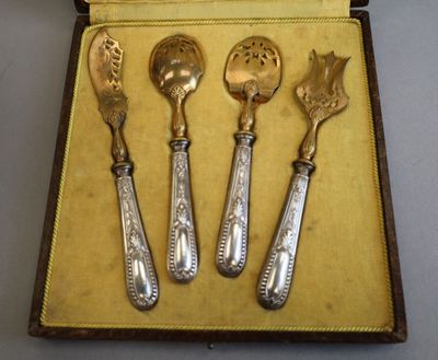 three spoons and a spoon rest in a case on a table