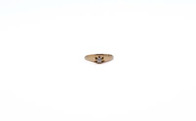 a gold ring with a diamond in it on a white surface
