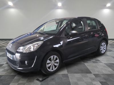 la photo d'une petite voiture noire garée sur un sol en damier
