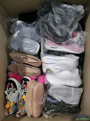 many pairs of shoes in a box with plastic wrap
