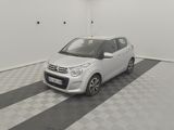a small white car parked in a room with a black and white checkered floor