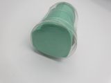 a plastic cup with a green lid sitting on a table