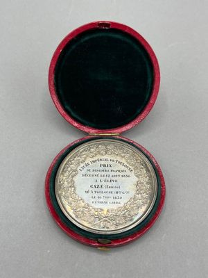 an image of a small red box with a silver medal in it
