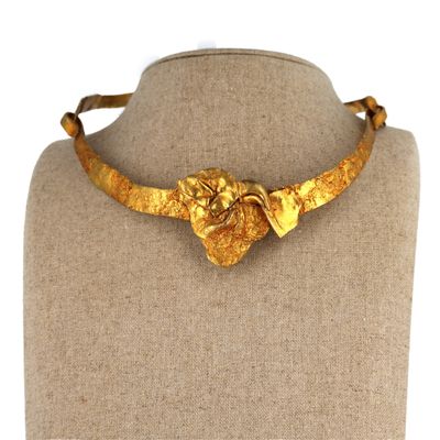 a close up of a gold necklace on a mannequin mannequin