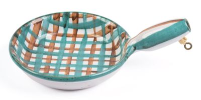 a green and white bowl with a handle on a white surface