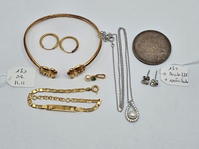 un gros plan sur un assortiment de bijoux posés sur une table, à côté d'une pièce de monnaie