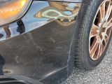a close up of a car ' s front bumper with a reflection of a building in the background