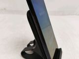 the back of a cell phone on a stand on a white surface