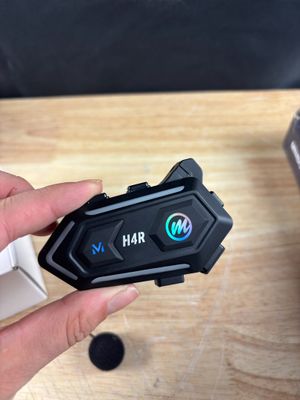 une personne tenant un appareil Bluetooth à la main