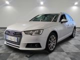 L'Audi blanche est garée sur un sol à damier dans un garage.