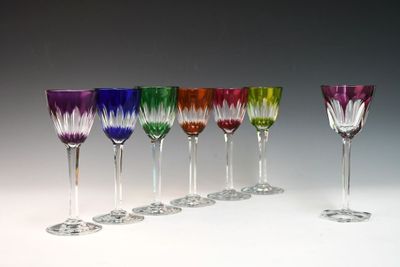 six wine glasses are lined up in a row on a white surface
