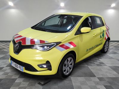 La voiture jaune est garée sur un sol à damier dans le garage.