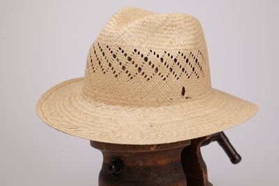 un chapeau de paille posé sur un support en bois