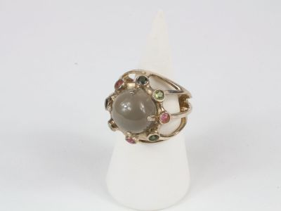 a close up of a ring with a stone in it on a white surface