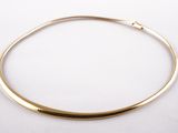 gros plan d'un collier en or sur une surface blanche
