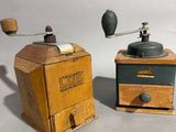 two old fashioned coffee grinders sitting next to each other