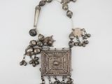 a silver necklace with silver beads and a square pendant