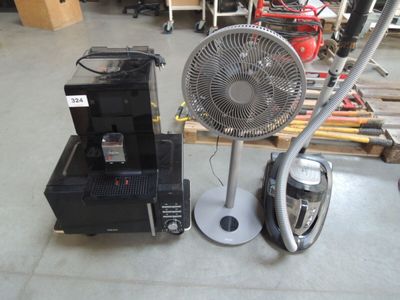 a fan sitting next to a small machine in a warehouse
