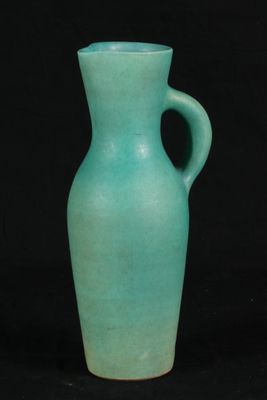 un vase vert posé sur une table noire