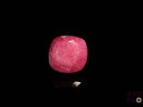 a pink apple that is sitting on a black surface