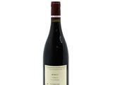 a bottle of red wine sitting on top of a white table