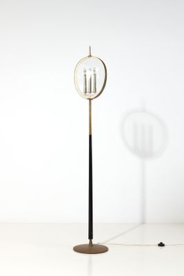 Le lampadaire est posé sur une surface blanche, à côté d'un mur blanc.