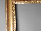 an antique gold frame with a decorative design on the wall