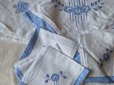 quatre serviettes de table posées sur un lit, ornées d'un motif bleu