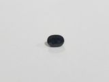 a small black stone sitting on top of a white surface